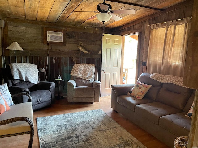 living room with wood-type flooring, wooden walls, a wall mounted AC, ceiling fan, and wooden ceiling