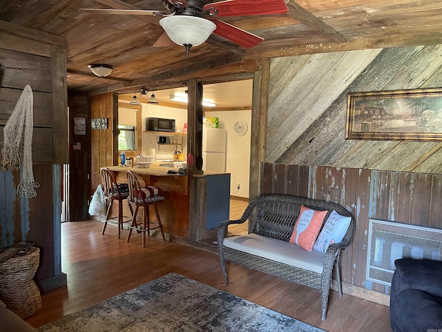 living room featuring wooden walls, hardwood / wood-style floors, ceiling fan, and vaulted ceiling