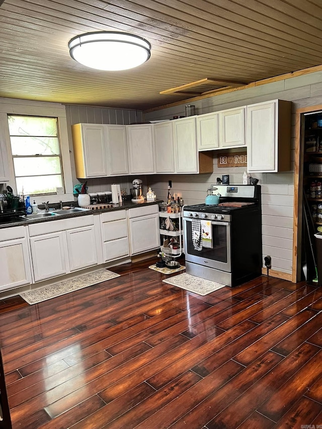 kitchen featuring stainless steel stove, white cabinets, sink, and dark wood-type flooring