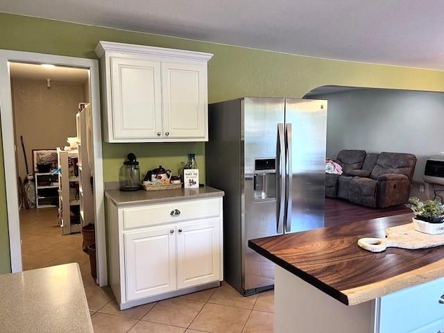 kitchen with white cabinetry, light tile patterned flooring, and stainless steel fridge with ice dispenser