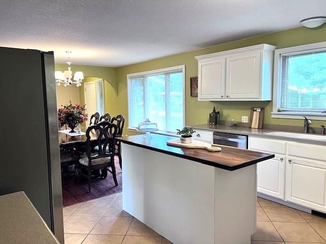 kitchen featuring light tile patterned floors, appliances with stainless steel finishes, a chandelier, and white cabinetry