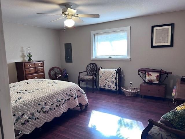 bedroom with ceiling fan, electric panel, and dark hardwood / wood-style flooring