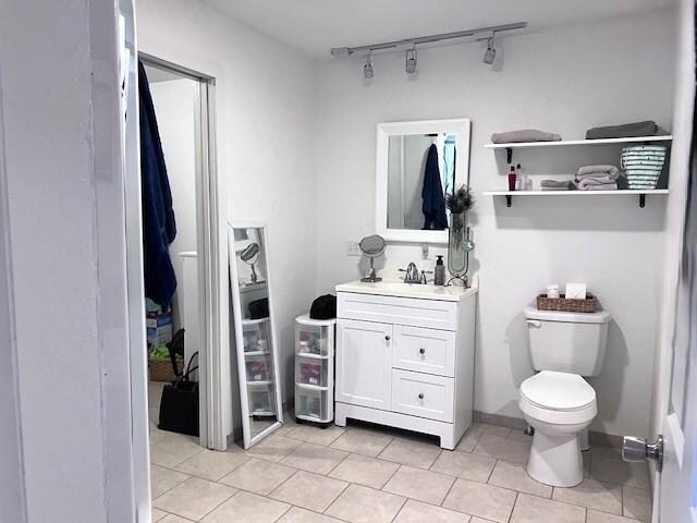 bathroom featuring rail lighting, vanity, toilet, and tile patterned floors