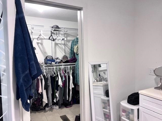 spacious closet with light tile patterned floors