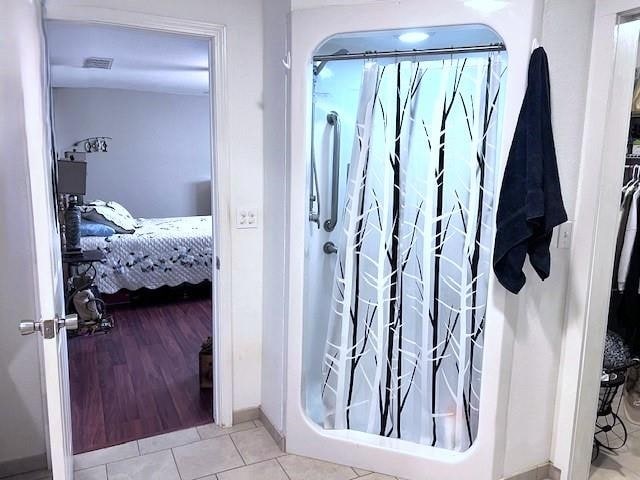 bathroom with tile patterned flooring and curtained shower