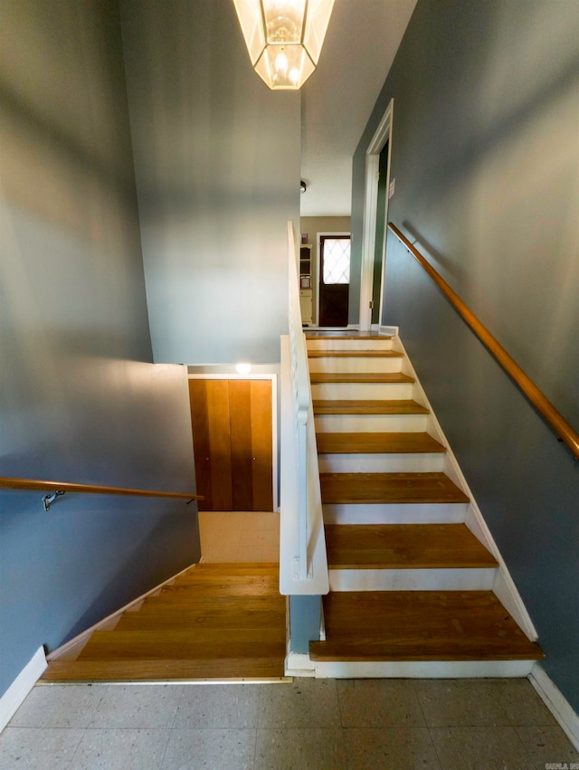 staircase with hardwood / wood-style floors