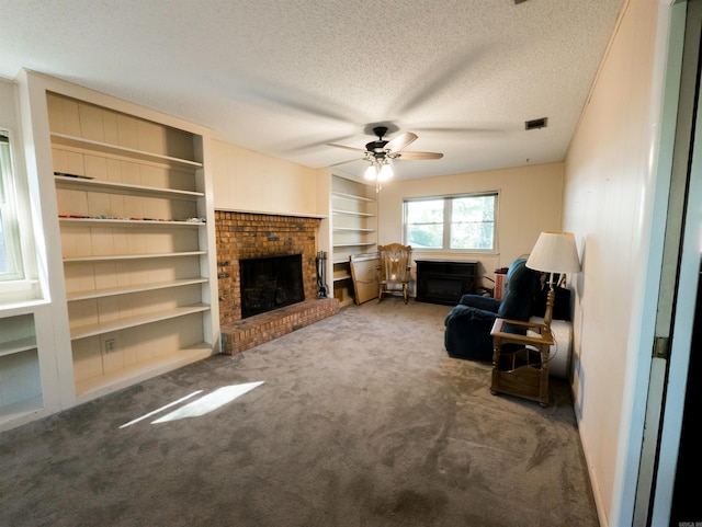 carpeted living room with ceiling fan, a textured ceiling, and a fireplace