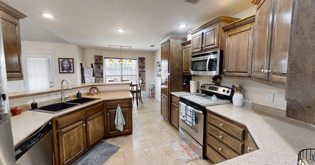 kitchen featuring appliances with stainless steel finishes, sink, and decorative light fixtures