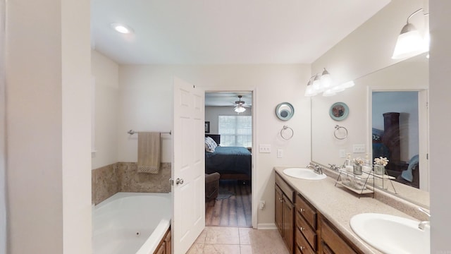 bathroom with ceiling fan, vanity, a bathing tub, and tile patterned floors