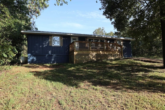 rear view of house featuring a yard and a wooden deck