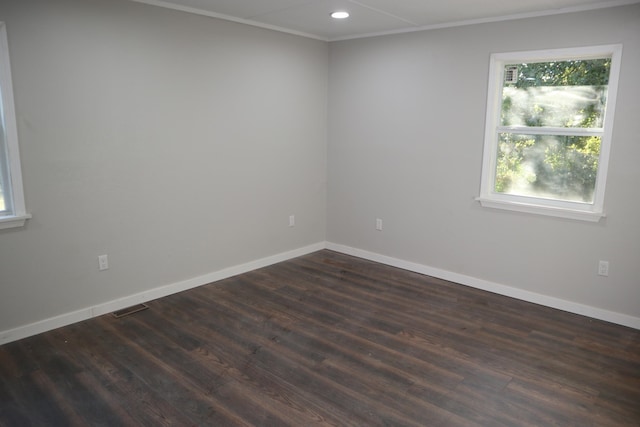 spare room featuring dark wood-type flooring and crown molding