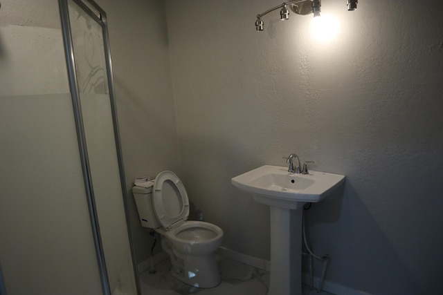 bathroom featuring toilet and a shower with door