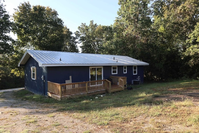 rear view of house with a lawn, cooling unit, and a wooden deck