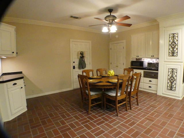 dining space with ornamental molding and ceiling fan