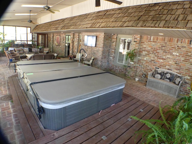 wooden deck featuring ceiling fan, a covered hot tub, an outdoor hangout area, and a patio