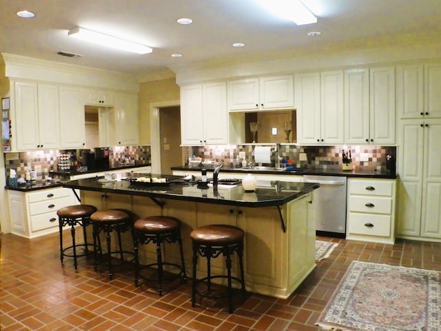 kitchen with white cabinets, dishwasher, an island with sink, and a breakfast bar