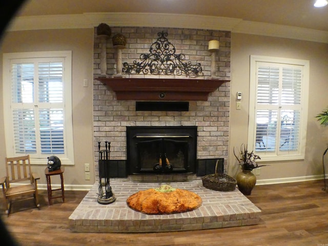 interior space with a brick fireplace and hardwood / wood-style flooring