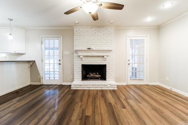 unfurnished living room featuring ceiling fan, hardwood / wood-style flooring, a fireplace, and crown molding