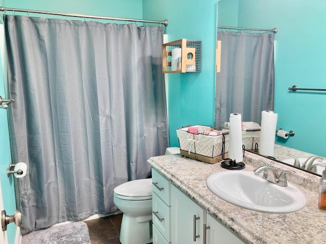 bathroom featuring tile patterned flooring, curtained shower, vanity, and toilet