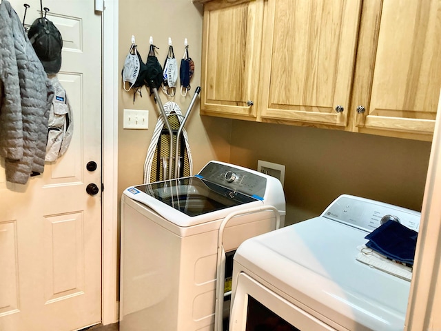 laundry area featuring washer and clothes dryer and cabinets