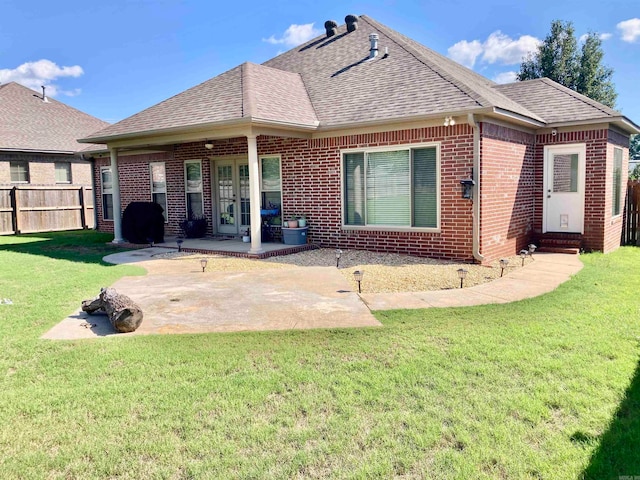 rear view of property with french doors, a lawn, and a patio