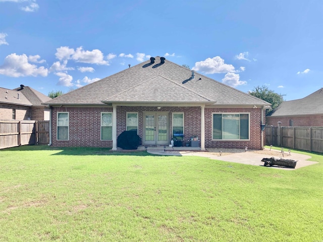 rear view of house with a patio, a yard, and an outdoor fire pit