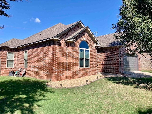 view of side of home with a lawn and a garage