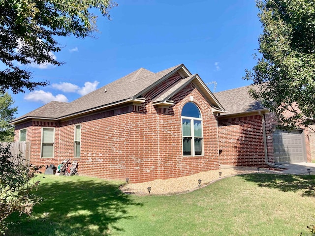 view of side of property with a yard and a garage