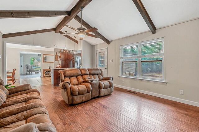 living room with lofted ceiling with beams, light hardwood / wood-style floors, ceiling fan, and plenty of natural light