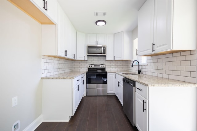 kitchen with decorative backsplash, white cabinetry, stainless steel appliances, dark hardwood / wood-style floors, and sink