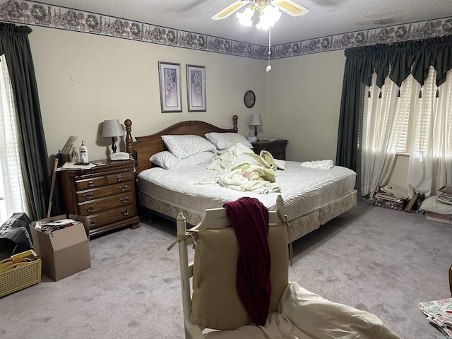 bedroom with light carpet, a textured ceiling, and ceiling fan