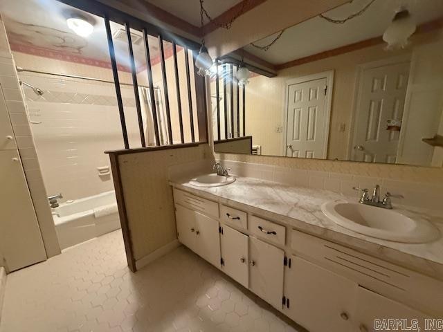 bathroom with vanity, tiled shower / bath combo, and tile patterned flooring