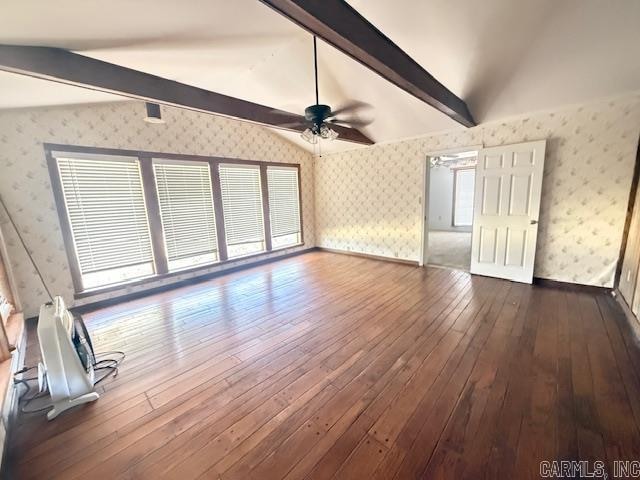 unfurnished living room featuring a wealth of natural light, lofted ceiling with beams, dark hardwood / wood-style floors, and ceiling fan