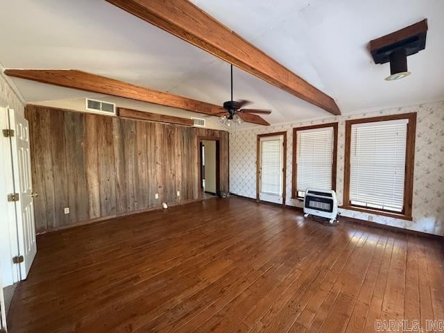 unfurnished living room with dark hardwood / wood-style floors, wooden walls, lofted ceiling with beams, heating unit, and ceiling fan