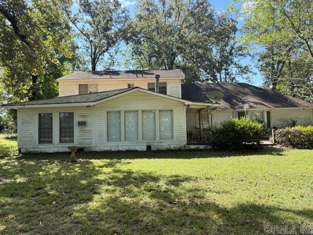 rear view of house featuring a lawn