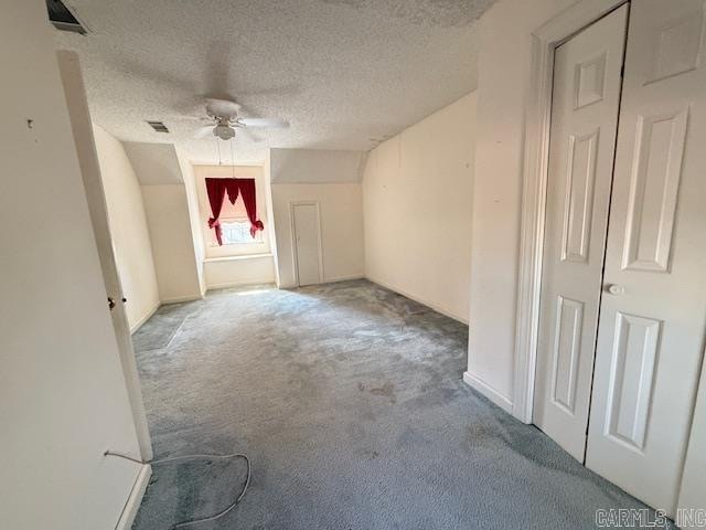 carpeted spare room with ceiling fan and a textured ceiling