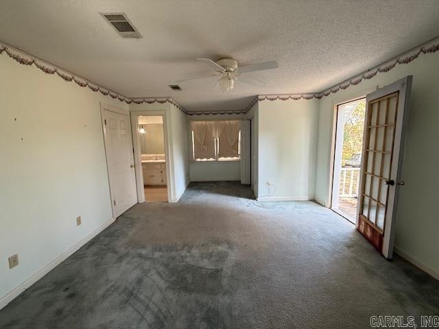 unfurnished bedroom with access to outside, dark carpet, ensuite bath, a textured ceiling, and ceiling fan