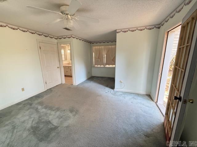 unfurnished bedroom featuring multiple windows, a textured ceiling, and ceiling fan