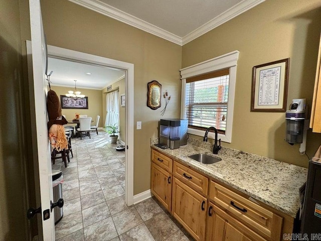 interior space with hanging light fixtures, ornamental molding, sink, an inviting chandelier, and light stone countertops