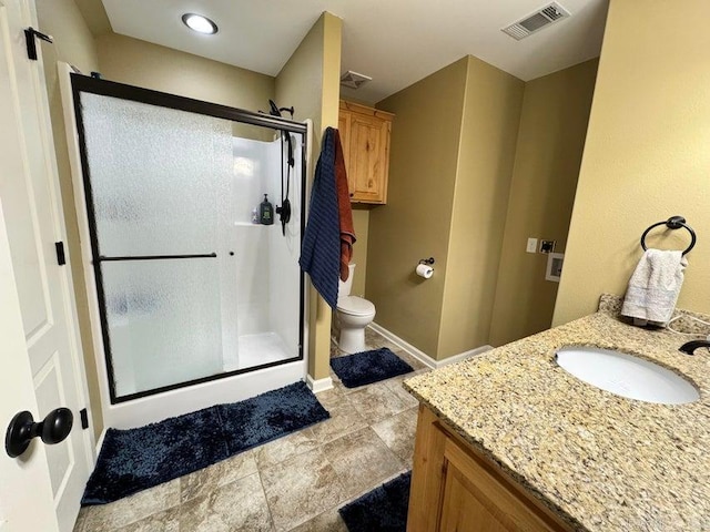 bathroom featuring vanity, toilet, and a shower with shower door