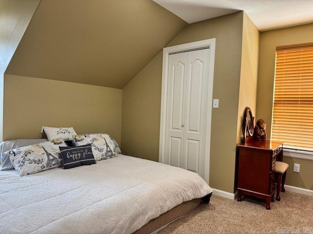 carpeted bedroom with vaulted ceiling and a closet