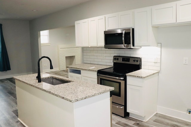 kitchen with white cabinets, light stone countertops, sink, and appliances with stainless steel finishes