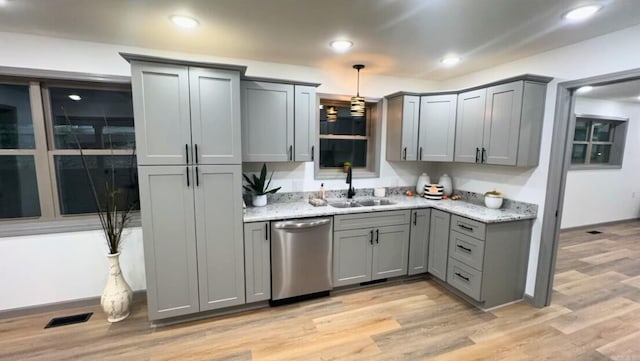 kitchen featuring gray cabinetry, stainless steel dishwasher, sink, and light hardwood / wood-style flooring