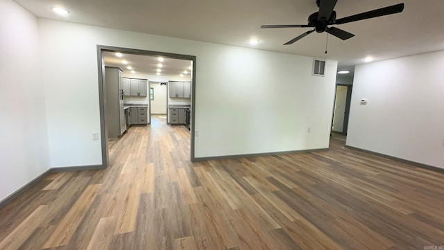 unfurnished room with ceiling fan and dark wood-type flooring