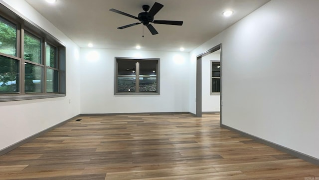 unfurnished room featuring ceiling fan and dark wood-type flooring