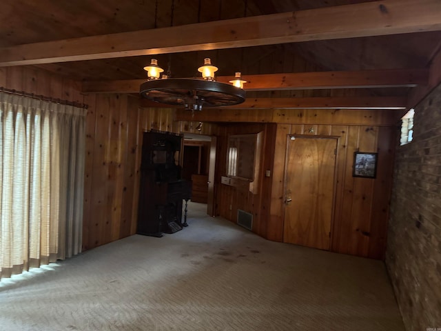 carpeted spare room featuring wood walls, wood ceiling, beam ceiling, and an inviting chandelier