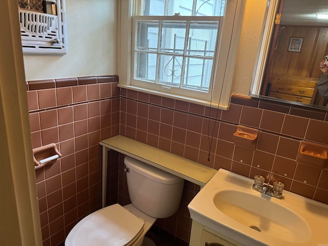 bathroom with tile walls, vanity, and toilet