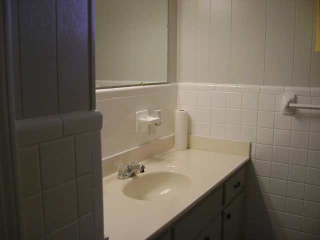 bathroom featuring vanity and tile walls