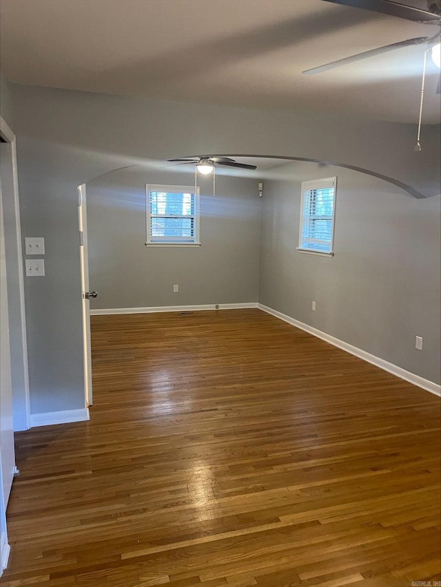 empty room with wood-type flooring, ceiling fan, and a wealth of natural light