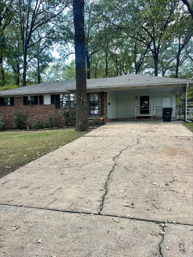 ranch-style house featuring a front yard and a carport